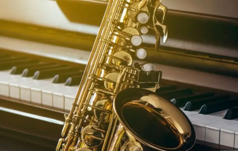 Saxophone resting on piano keys